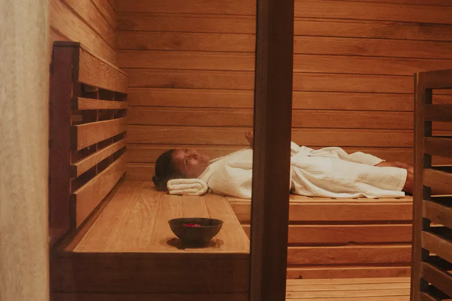 A guest lying inside a cedar herbal steam cabinet at the lodge spa